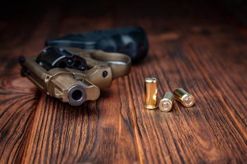 pistol and cartridges on a wooden background