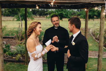 Bride and groom exchanging wedding vows on wedding ceremony