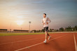 © ittipol - Athlete runs around the stadium with sunset or sunrise background