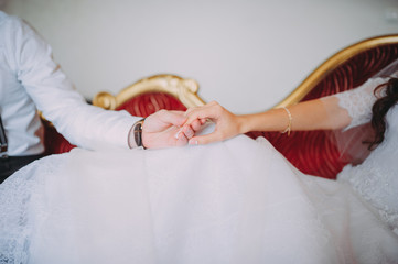 Wall Mural - Hand in hand closeup. The bride and groom in hotel room