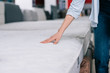 © LIGHTFIELD STUDIOS - partial view of woman touching orthopedic mattress in furniture shop