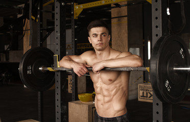 Wall Mural - Healthy young man standing strong in the gym and flexing muscles - muscular athletic bodybuilder fitness model posing after exercises