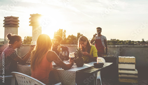 Cuadros en Lienzo Young friends having barbecue party at sunset on penthouse patio
