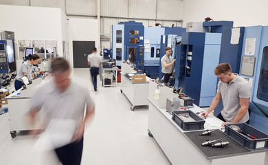 Wall Mural - busy engineering workshop with workers using cnc machinery