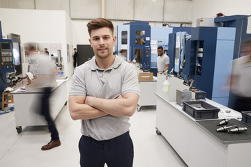 Wall Mural - portrait of male engineer on factory floor of busy workshop