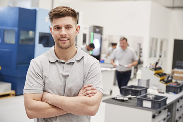 Wall Mural - portrait of male engineer on factory floor of busy workshop