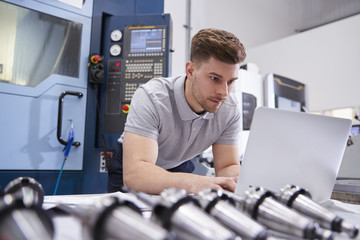 male engineer using cad programming software on laptop