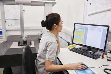 Wall Mural - female engineer uses cmm coordinate measuring machine in factory