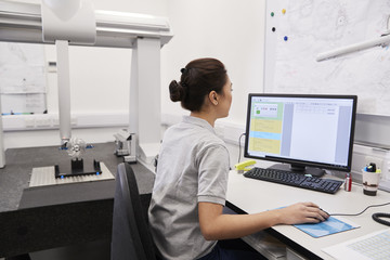 Wall Mural - female engineer uses cmm coordinate measuring machine in factory