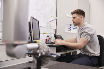 Wall Mural - male engineer uses cmm coordinate measuring machine in factory