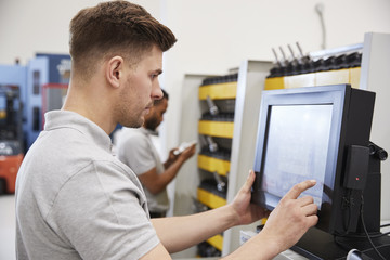 Wall Mural - engineers selecting tools for use on machinery in factory