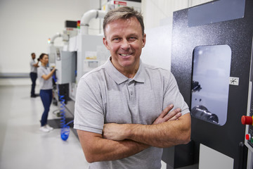 Wall Mural - portrait of male engineer operating cnc machinery in factory