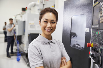 Wall Mural - portrait of female engineer operating cnc machinery in factory