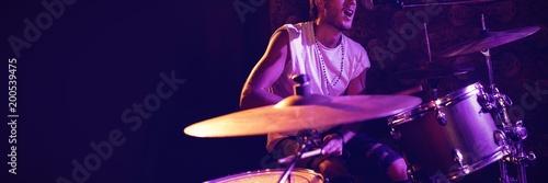 Fotomural Singer playing drums while performing in nightclub