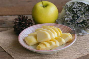 Wall Mural - Fresh Shinano gold apple cut and sliced to piece ready to eat on plate put on wood table. Prepare delicious and healthy fruit for snack with family. Sweet sour juicy and crisp apple breed from Japan.