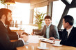 © freeograph - Meeting with chinese businessmen in restaurant. They are discussing point in documents.