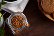 Open jar of instant coffee arranged on woden table, top view, close-up, selective focus.