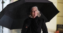 Confident Caucasian Female Elder Holding Umbrella Outside On Rainy Day