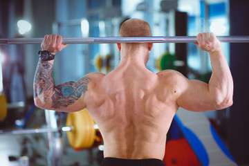 Wall Mural - Bodybuilder with barbell in gym. Bodybuilder