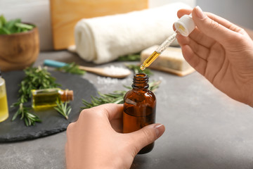 Woman with bottle of essential oil, closeup