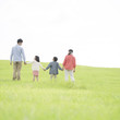 © amanaimages - 草原で手をつなぐ家族の後姿