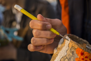 The hand of the artist. Work with a sharp tool. The execution of the decorative sculpture made of paper.