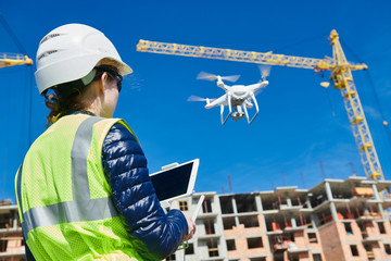 Wall Mural - drone inspection. operator inspecting construction building site flying with drone