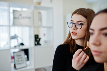 Wall Mural - Make up artist work in her beauty visage studio salon. Woman applying by professional make up master. Beauty club concept.