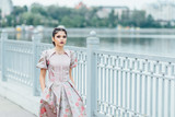 Fototapeta Krajobraz - The girl on the bank of the lake. The girl is dressed in a beuti