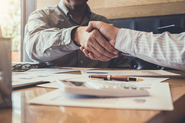 Wall Mural - Greeting new colleagues team, business people shaking hands during a meeting to sign agreement and become a business partner, Successful businessman handshake after good deal for both companies