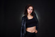 © AS Photo Family - Studio portrait of sexy brunette girl in black leather jacket against black background.