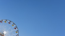 Cropped Shot Of A Ferris Wheel Against Blue Clear Sky With Copy Space, Concept For Freedom, Enjoyment, Amusement Park And Nostalgia For Childhood Fun Memories