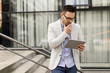 © BGStock72 - Young businessman with digital tablet by the office building
