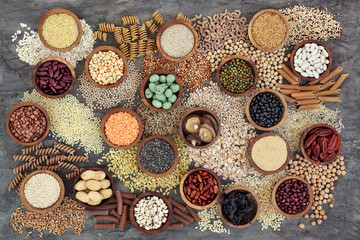 Wall Mural - Dried macrobiotic health food with grains, cereals, pulses, nuts, seeds and whole wheat pasta. Super foods high in smart carbohydrates, protein, antioxidants and fibre on marble background top view.