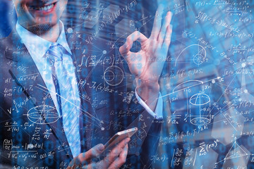 Wall Mural - Side portrait of handsome young businessman writing mathematical formulas on bright city background