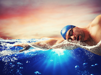 Wall Mural - Boy swims in a blue deep water