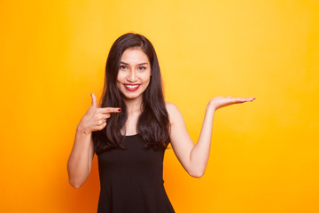 Beautiful young Asian woman point to palm hand.