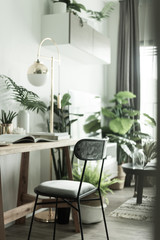 Wall Mural - Working corner in apartment with Scandinavian style decoration and artificial plants in background / Cozy Interior Concept / Work from home