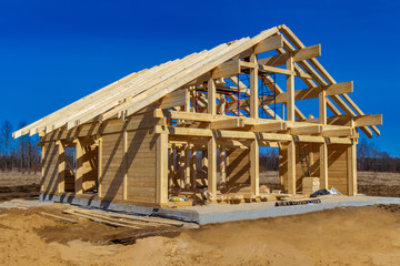 The beginning of the cottage construction. Wooden frame of the cottage. Building construction. Building construction services. The project of the house from a bar.