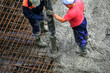 Builders works on the construction site: pouring concrete for foundation