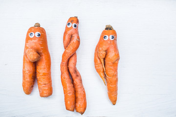 Wall Mural - Funny shape of carrot with eyes on white board background. Copy space