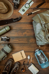 Wall Mural - camping gear including knife, clothes, boots, lantern, camera, hat, map, compass. vertical wanderlus