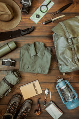 Wall Mural - camping gear including knife, clothes, boots, lantern, camera, hat, map, compass. vertical wanderlus