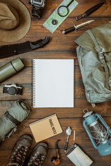 Wall Mural - camping gear including knife, clothes, boots, lantern, camera, hat, map, compass. vertical wanderlus