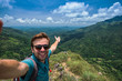 © RealPeopleStudio - Caucasian man on top of mountain making selfie on background of pretty landscape