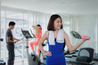 © Vittaya_25 - young asian pretty woman slim body doing exercises with dumbbell at biceps for good healthy in fitness gym at morning with people background, bodybuilder, lifestyle and sport exercise concept