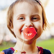 Humorous photo. Fake lips without surgery. Funny cute little child girl holding fake paper smile in front of lips