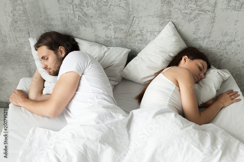 Unhappy Indifferent Couple Sleeping Separately Back To Back