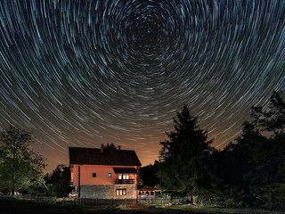 Wall Mural - Star trails above the house. Residential building and the star trails on the sky. The night sky is astronomically accurate.