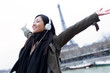 © nenetus - Excited asian young woman listening to music and enjoying moment in front of Eiffel tower in Paris.